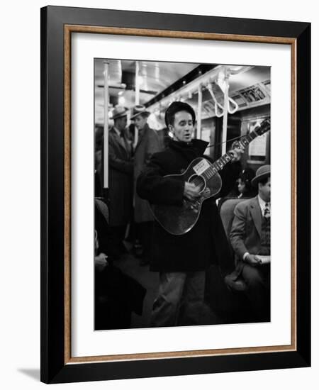 Folk Singer Woody Guthrie Singing Aboard a Subway Train-null-Framed Premium Photographic Print