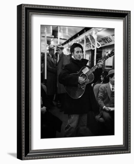 Folk Singer Woody Guthrie Singing Aboard a Subway Train-null-Framed Premium Photographic Print