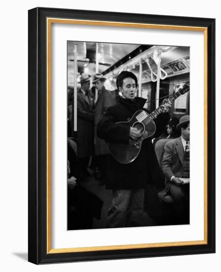 Folk Singer Woody Guthrie Singing Aboard a Subway Train-null-Framed Premium Photographic Print