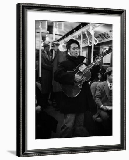 Folk Singer Woody Guthrie Singing Aboard a Subway Train-null-Framed Premium Photographic Print