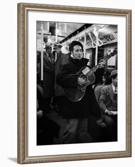 Folk Singer Woody Guthrie Singing Aboard a Subway Train-null-Framed Premium Photographic Print