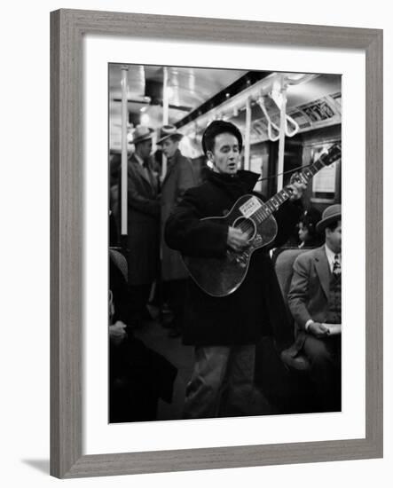 Folk Singer Woody Guthrie Singing Aboard a Subway Train-null-Framed Premium Photographic Print