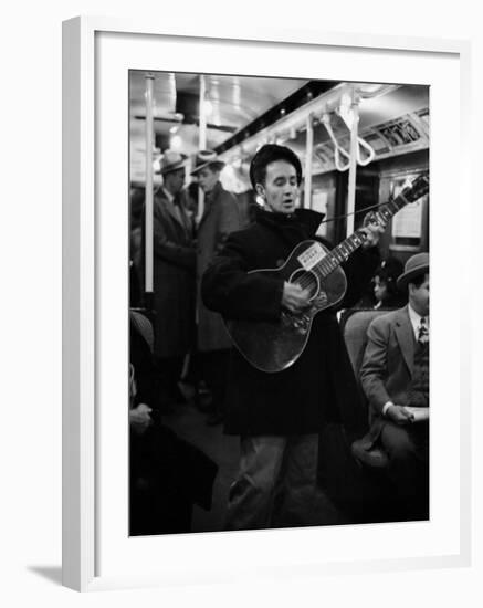 Folk Singer Woody Guthrie Singing Aboard a Subway Train-null-Framed Premium Photographic Print