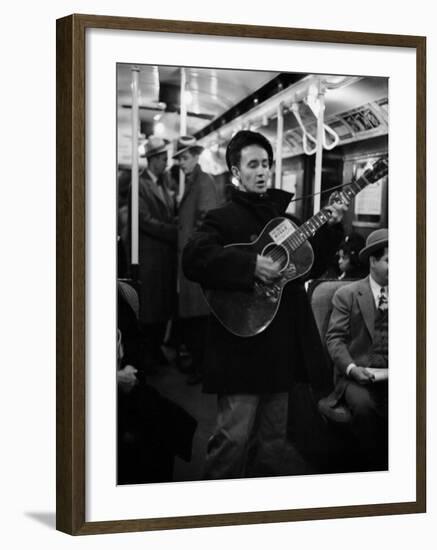 Folk Singer Woody Guthrie Singing Aboard a Subway Train-null-Framed Premium Photographic Print