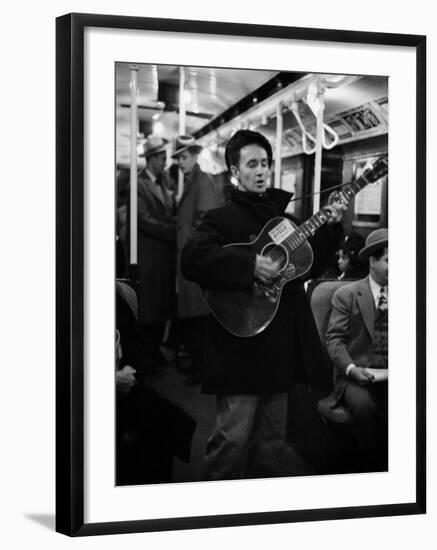 Folk Singer Woody Guthrie Singing Aboard a Subway Train-null-Framed Premium Photographic Print