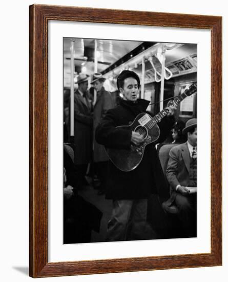 Folk Singer Woody Guthrie Singing Aboard a Subway Train-null-Framed Premium Photographic Print