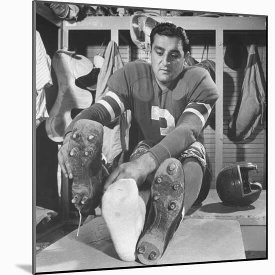 Football Player Ben Agajanian Putting on Football Cleats-Allan Grant-Mounted Premium Photographic Print