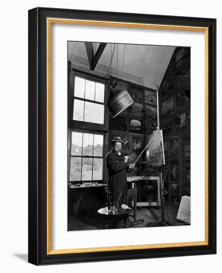 Former PM Winston Churchill Smoking a Cigar in His Studio Dressed in His Blue RAF Siren Jump Suit-Hans Wild-Framed Photographic Print