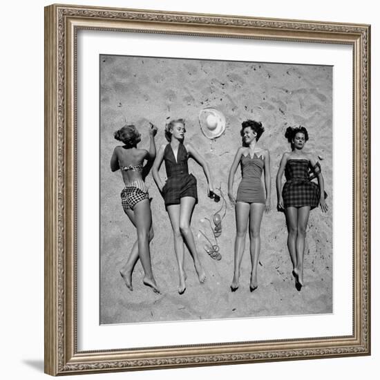 Four Models Showing Off the Latest Bathing Suit Fashions While Laying on a Sandy Florida Beach-Nina Leen-Framed Photographic Print