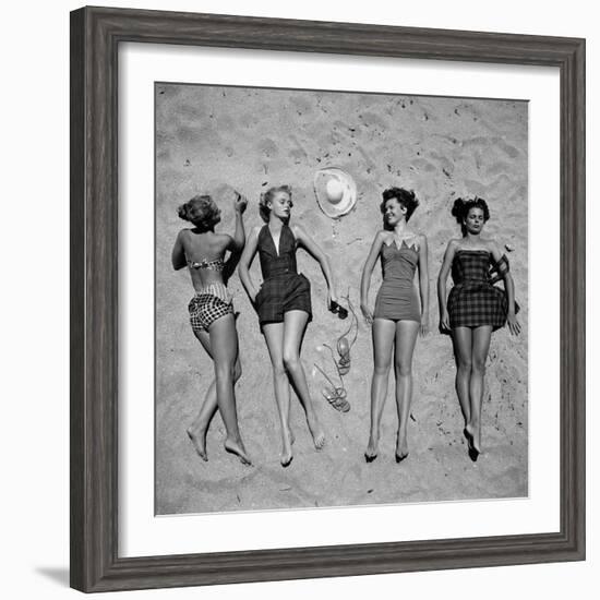 Four Models Showing Off the Latest Bathing Suit Fashions While Laying on a Sandy Florida Beach-Nina Leen-Framed Photographic Print