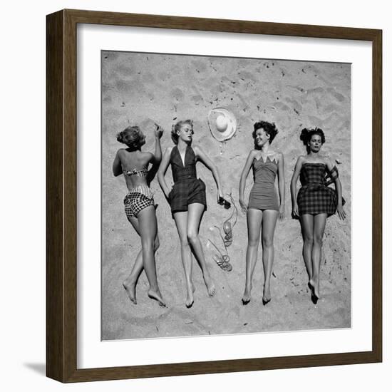 Four Models Showing Off the Latest Bathing Suit Fashions While Laying on a Sandy Florida Beach-Nina Leen-Framed Photographic Print