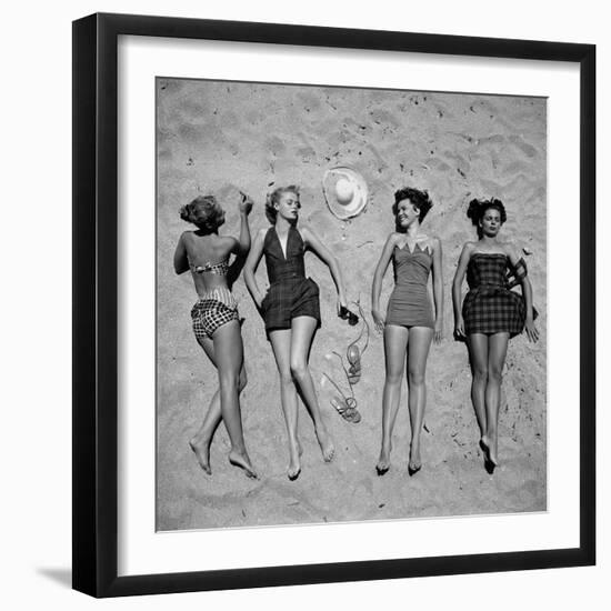 Four Models Showing Off the Latest Bathing Suit Fashions While Laying on a Sandy Florida Beach-Nina Leen-Framed Photographic Print