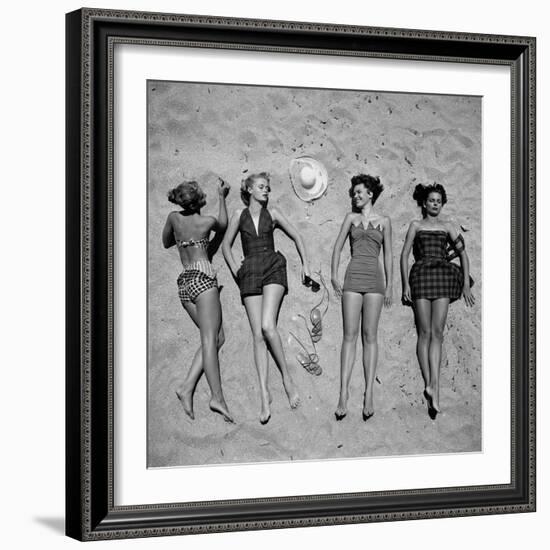 Four Models Showing Off the Latest Bathing Suit Fashions While Laying on a Sandy Florida Beach-Nina Leen-Framed Photographic Print