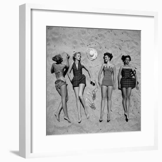 Four Models Showing Off the Latest Bathing Suit Fashions While Laying on a Sandy Florida Beach-Nina Leen-Framed Photographic Print