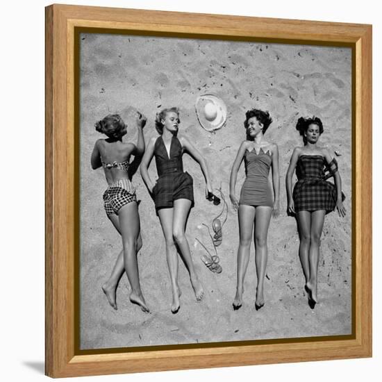 Four Models Showing Off the Latest Bathing Suit Fashions While Lying on a Sandy Florida Beach-Nina Leen-Framed Premier Image Canvas