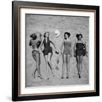 Four Models Showing Off the Latest Bathing Suit Fashions While Lying on a Sandy Florida Beach-Nina Leen-Framed Photographic Print