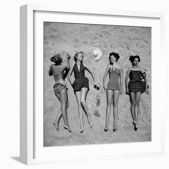 Four Models Showing Off the Latest Bathing Suit Fashions While Lying on a Sandy Florida Beach-Nina Leen-Framed Photographic Print