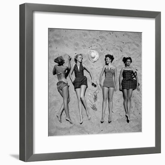 Four Models Showing Off the Latest Bathing Suit Fashions While Lying on a Sandy Florida Beach-Nina Leen-Framed Photographic Print