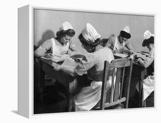 Four Young British Student Nurses Making Notes Together from Medical Textbooks-null-Framed Premier Image Canvas