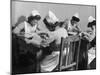 Four Young British Student Nurses Making Notes Together from Medical Textbooks-null-Mounted Photographic Print