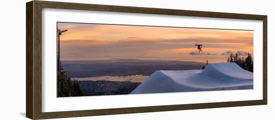 Freestyle skier doing a trick off a jump above city at sunset, Canada, North America-Tyler Lillico-Framed Photographic Print