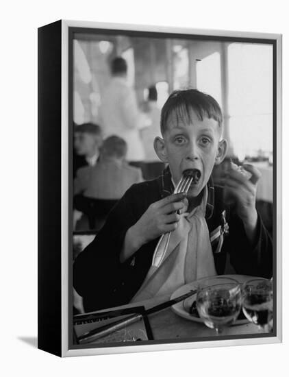 French Boy Andre Poindeeault Mastering a Big Bite-Nat Farbman-Framed Premier Image Canvas