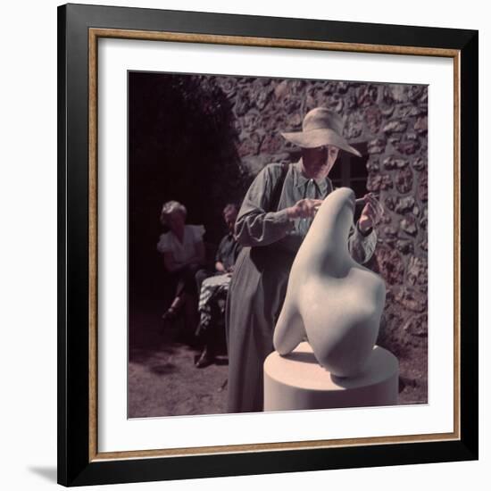 French Sculptor Jean Arp, Alone, Polishing Abstract Sculpture in His Garden Near Paris-Gjon Mili-Framed Premium Photographic Print