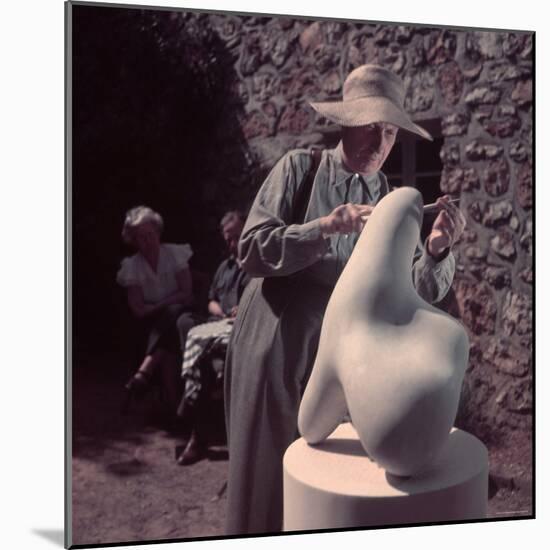 French Sculptor Jean Arp, Alone, Polishing Abstract Sculpture in His Garden Near Paris-Gjon Mili-Mounted Premium Photographic Print