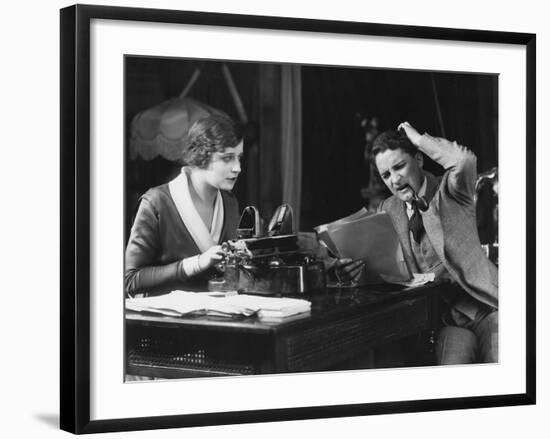 Frowning Manager Reviewing Secretary's Work-null-Framed Photo