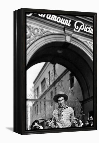 Gary Cooper poses with revolvers in his hands-null-Framed Stretched Canvas