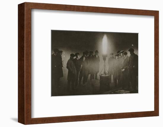 Gathering around an acetylene flare at a traffic control point in the fog, early 20th century-Unknown-Framed Photographic Print