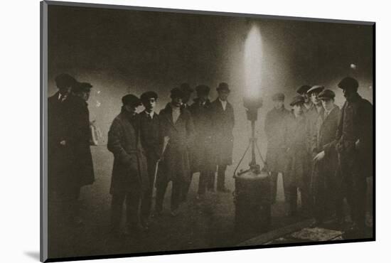 Gathering around an acetylene flare at a traffic control point in the fog, early 20th century-Unknown-Mounted Photographic Print