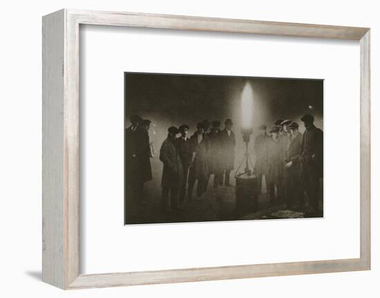 Gathering around an acetylene flare at a traffic control point in the fog, early 20th century-Unknown-Framed Photographic Print