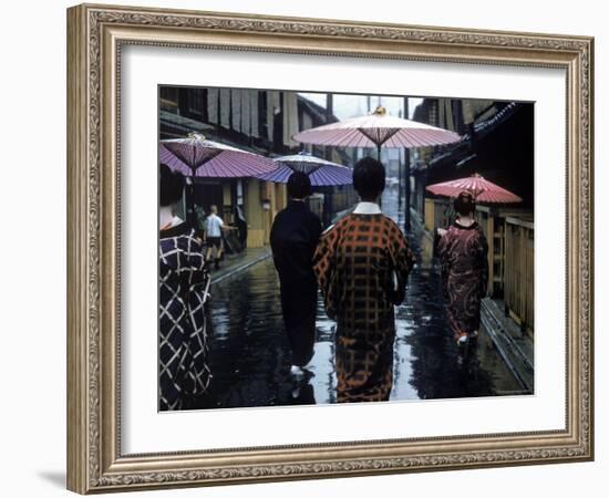 Geishas Carry Umbrellas of Oiled Japanese Paper Wearing Geta Walking in Rain, Gion Geisha Quarter-Eliot Elisofon-Framed Photographic Print