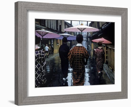 Geishas Carry Umbrellas of Oiled Japanese Paper Wearing Geta Walking in Rain, Gion Geisha Quarter-Eliot Elisofon-Framed Photographic Print