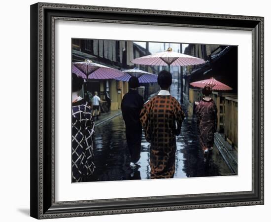 Geishas Carry Umbrellas of Oiled Japanese Paper Wearing Geta Walking in Rain, Gion Geisha Quarter-Eliot Elisofon-Framed Photographic Print