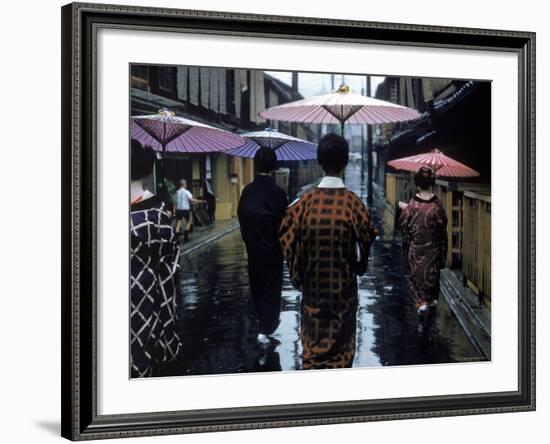 Geishas Carry Umbrellas of Oiled Japanese Paper Wearing Geta Walking in Rain, Gion Geisha Quarter-Eliot Elisofon-Framed Photographic Print