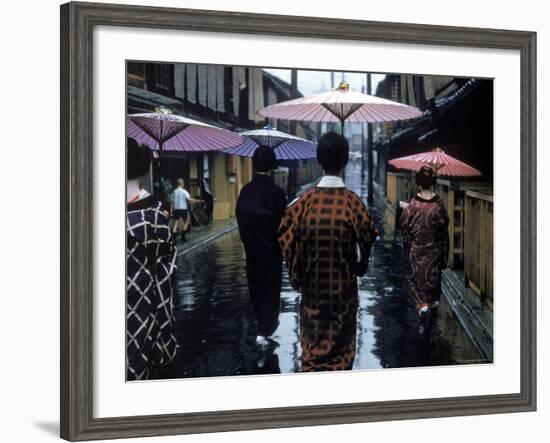 Geishas Carry Umbrellas of Oiled Japanese Paper Wearing Geta Walking in Rain, Gion Geisha Quarter-Eliot Elisofon-Framed Photographic Print