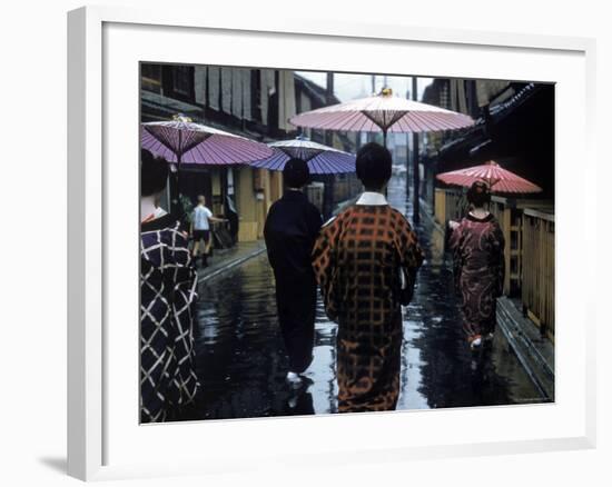 Geishas Carry Umbrellas of Oiled Japanese Paper Wearing Geta Walking in Rain, Gion Geisha Quarter-Eliot Elisofon-Framed Photographic Print