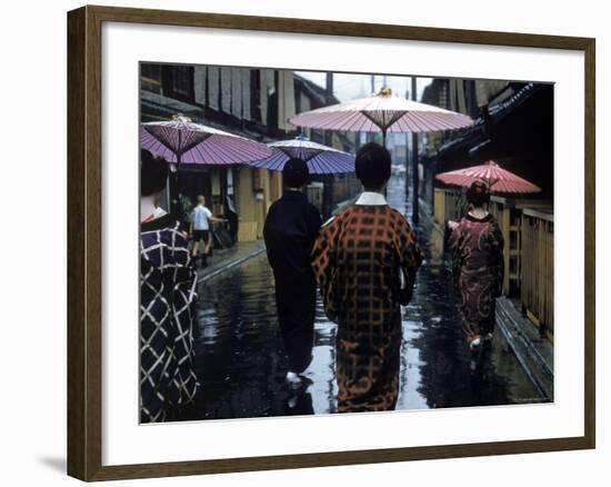 Geishas Carry Umbrellas of Oiled Japanese Paper Wearing Geta Walking in Rain, Gion Geisha Quarter-Eliot Elisofon-Framed Photographic Print