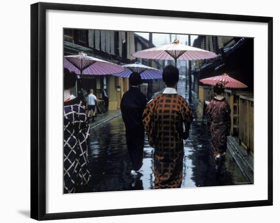 Geishas Carry Umbrellas of Oiled Japanese Paper Wearing Geta Walking in Rain, Gion Geisha Quarter-Eliot Elisofon-Framed Photographic Print