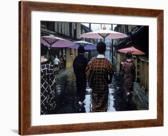 Geishas Carry Umbrellas of Oiled Japanese Paper Wearing Geta Walking in Rain, Gion Geisha Quarter-Eliot Elisofon-Framed Photographic Print