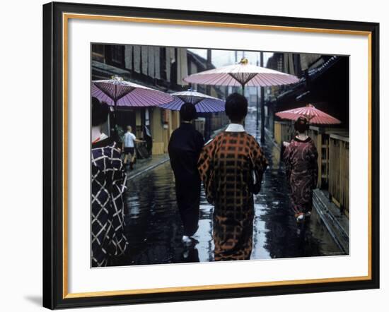 Geishas Carry Umbrellas of Oiled Japanese Paper Wearing Geta Walking in Rain, Gion Geisha Quarter-Eliot Elisofon-Framed Photographic Print