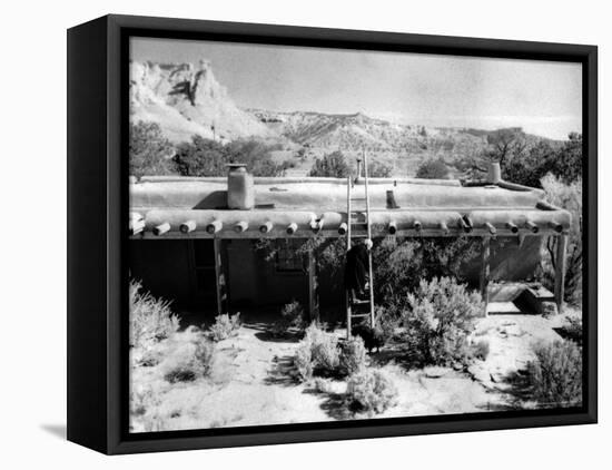 Georgia O'Keeffe Climbing a Ladder Outside Ghost Ranch, Her Desert Home-John Loengard-Framed Premier Image Canvas