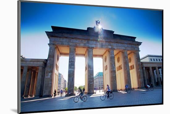 Germany, Berlin. Cyclists Passing under the Brandenburg Gate-Ken Scicluna-Mounted Photographic Print