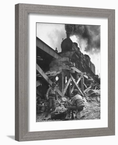 Gi Infantry Guards Keeping Warm by a Fire Next to an Army Engineer Built Railroad Bridge-Ralph Morse-Framed Photographic Print