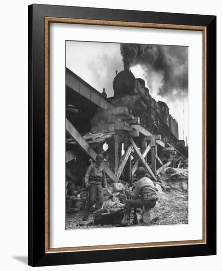 Gi Infantry Guards Keeping Warm by a Fire Next to an Army Engineer Built Railroad Bridge-Ralph Morse-Framed Photographic Print