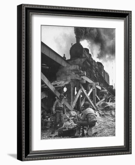 Gi Infantry Guards Keeping Warm by a Fire Next to an Army Engineer Built Railroad Bridge-Ralph Morse-Framed Photographic Print