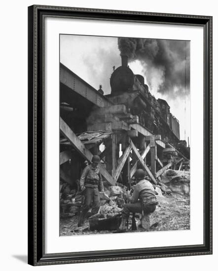 Gi Infantry Guards Keeping Warm by a Fire Next to an Army Engineer Built Railroad Bridge-Ralph Morse-Framed Photographic Print