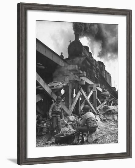 Gi Infantry Guards Keeping Warm by a Fire Next to an Army Engineer Built Railroad Bridge-Ralph Morse-Framed Photographic Print